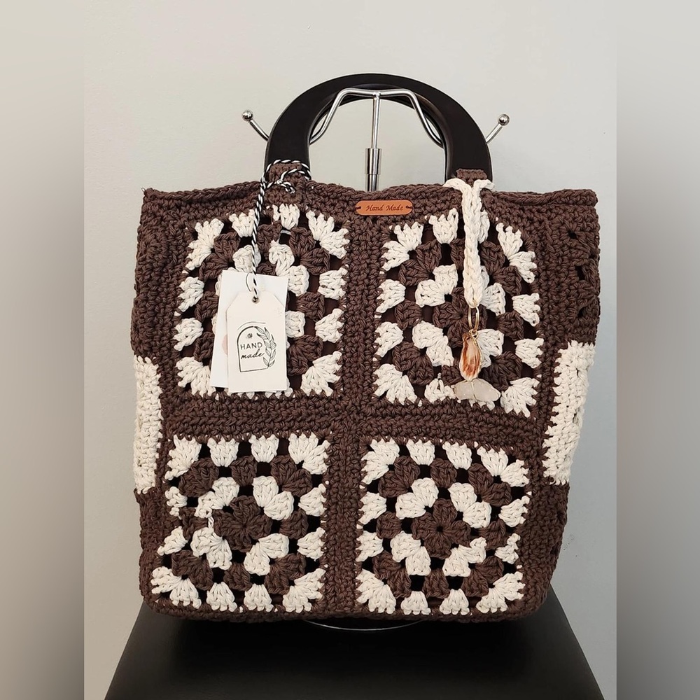 Medium sized brown and white handmade handbag with wooden handles.